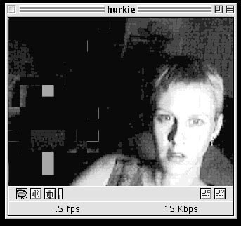 Vintage GUI of a media player showing a person with short hair wearring earrings and a tanktop directly staring eyes wide-openly at the camera.